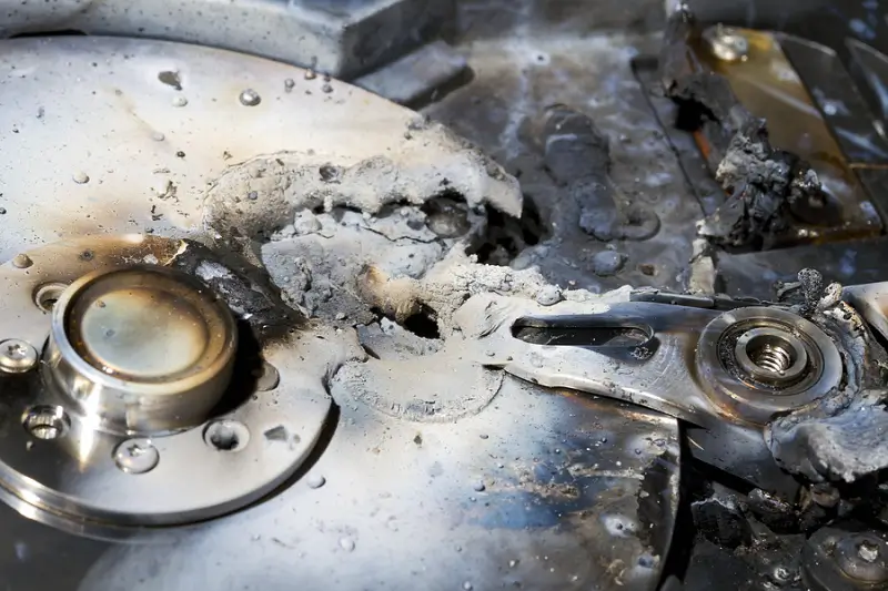 A hard drive with fire damage and melted components.