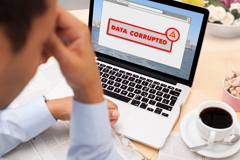 An image of a person looking at a corruption error on a laptop.