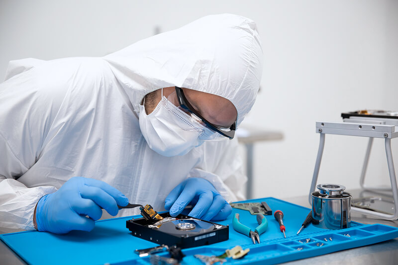 An image of a data recovery engineer fixing a hard drive in a certified cleanroom.